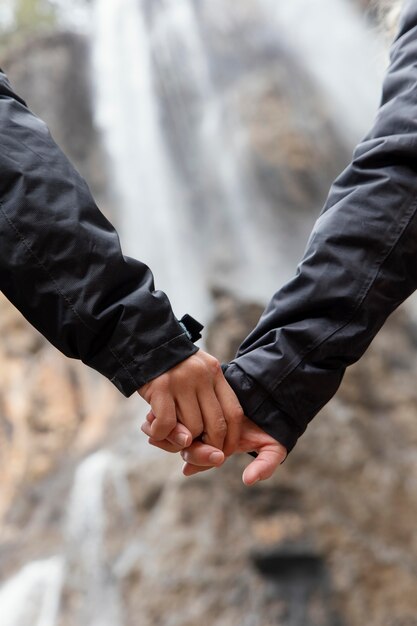 Pareja en la naturaleza tomados de la mano de cerca