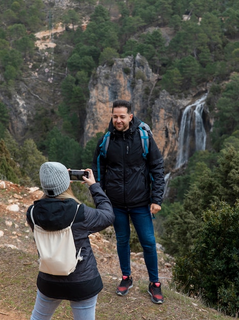 Foto gratuita pareja en la naturaleza tomando fotos con el móvil