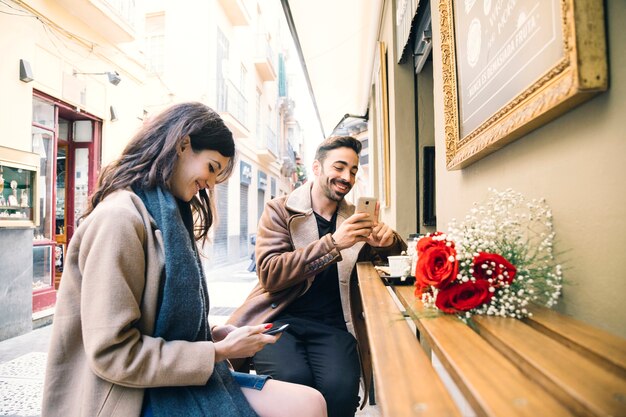 Pareja navegando por teléfonos inteligentes en la fecha