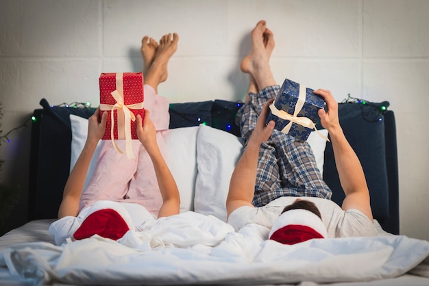 Pareja de Navidad con regalos en la cama