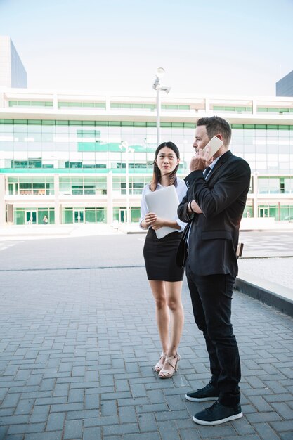 Pareja de negocios elegante haciendo una llamada