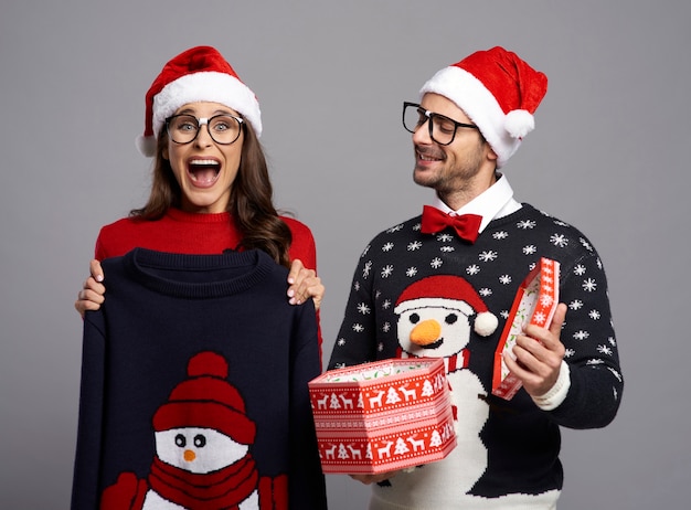 Pareja nerd abriendo regalo de Navidad