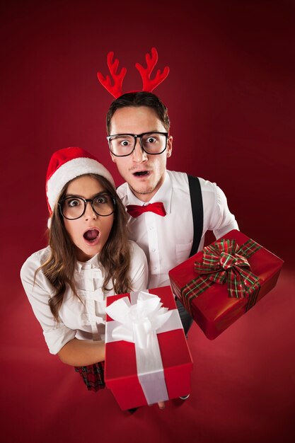 Pareja nerd sorpresa con regalos de navidad