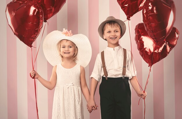 Pareja de niños y montón de globos