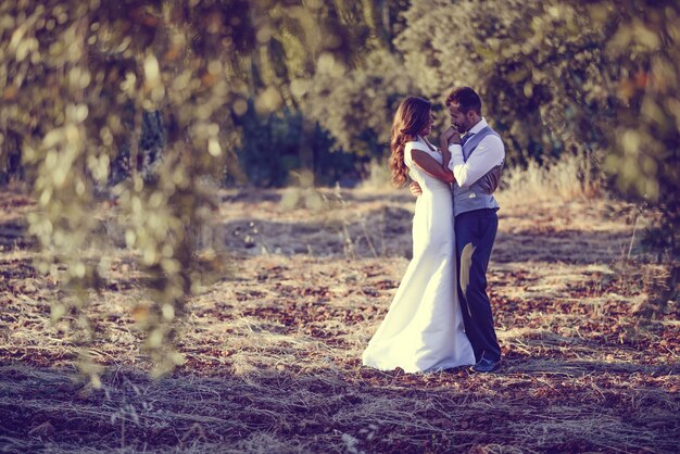 Pareja de novios abrazándose en el campo