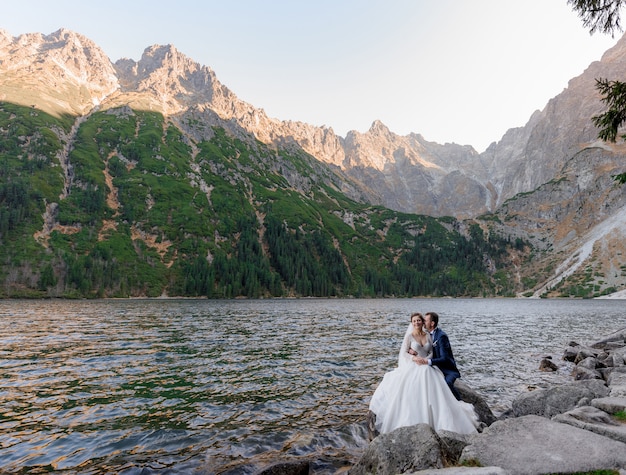 Pareja de novios se besa cerca del lago en las montañas de otoño, Morskie oko