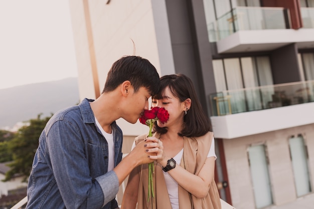 Pareja oliendo una rosa