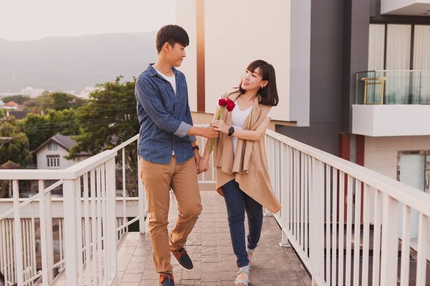 Pareja paseando agarrados a una rosa