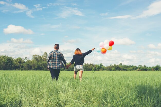 Pareja paseando con globos de colores