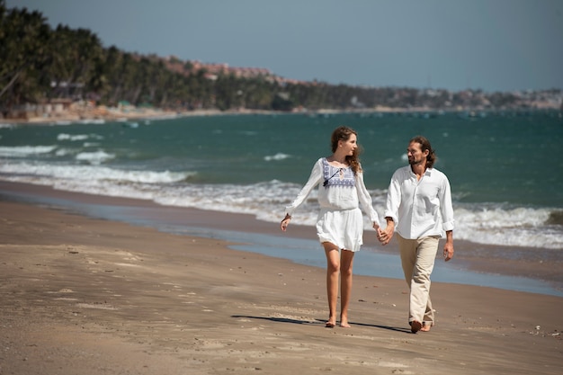 Pareja paseando por la playa durante las vacaciones