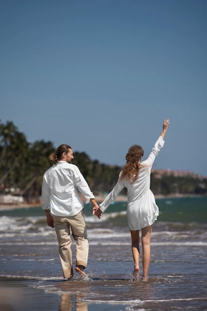 Pareja paseando por la playa durante las vacaciones