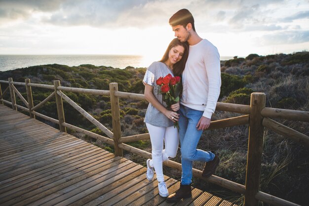 Pareja paseando por un puente de madera al atardecer