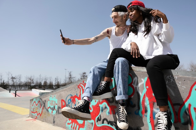 Foto gratuita pareja de patinadores con sombrero de camionero