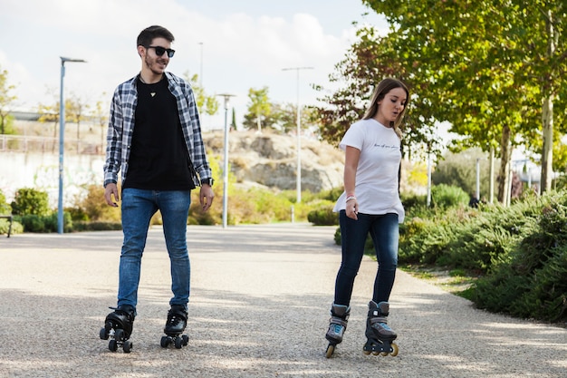 Foto gratuita pareja patinar en el parque