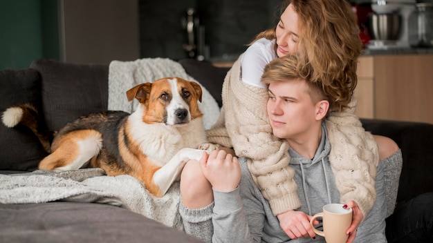 Pareja con perro abrazando