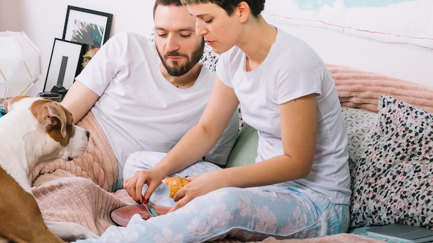 Pareja con perro en la cama