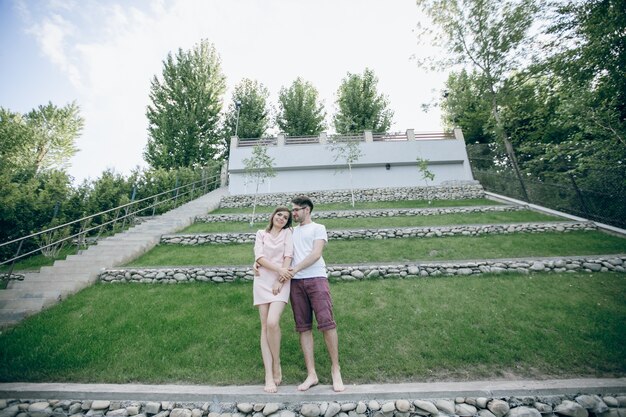 Pareja de pie agarrada de la mano en unos jardines