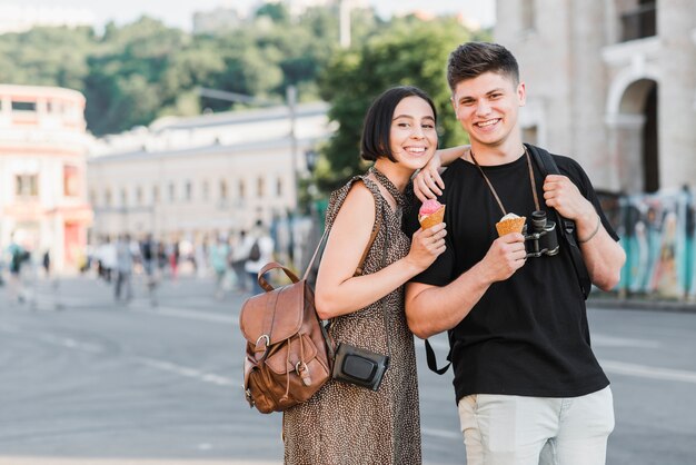 Pareja de pie en la calle con helado