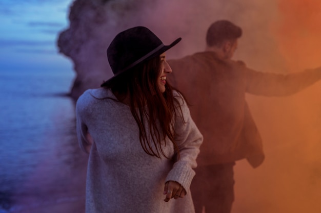 Pareja de pie en el humo en la orilla del mar