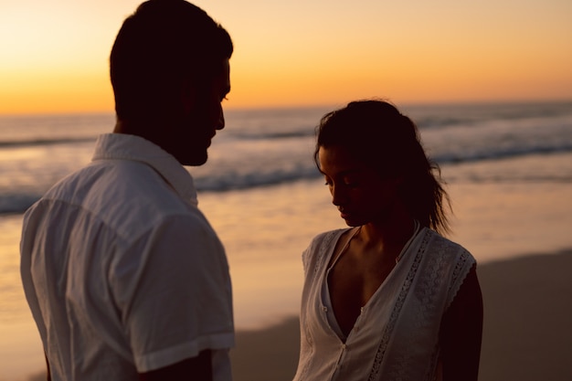 Pareja de pie juntos en la playa