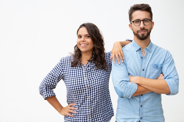 Pareja de pie juntos y sonriendo a la cámara