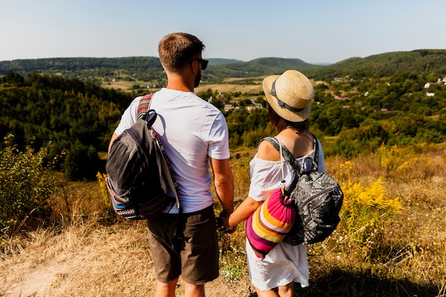 Foto gratuita pareja de pie y mirando lejos de tiro detrás