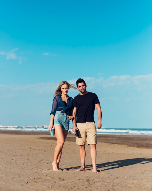 Pareja de pie en la playa de arena