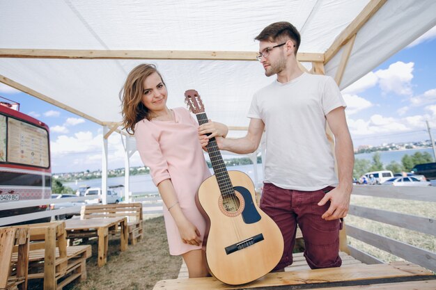 Pareja de pie sujetando una guitarra