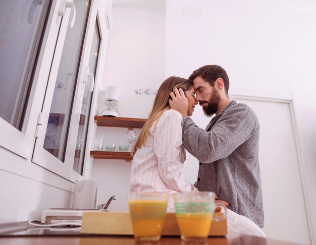 Pareja en pijama abrazando en cocina