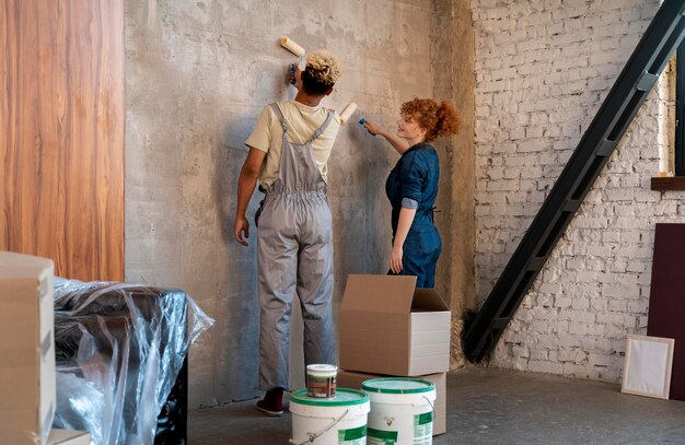 Pareja pintando su nuevo hogar juntos