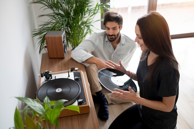 Pareja de plano medio con disco de vinilo.