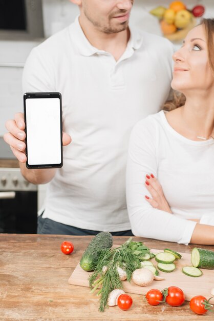 Pareja con plantilla de smartphone en cocina