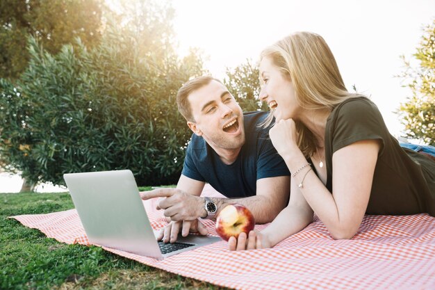 Pareja con portátil mirando el uno al otro