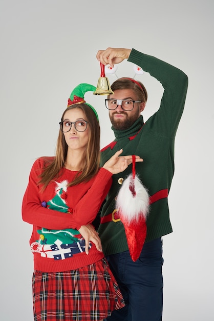 Foto gratuita pareja posando con campana y calcetín de navidad