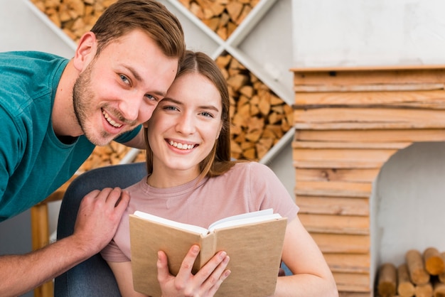 Pareja posando mientras sonríe y sostiene el libro