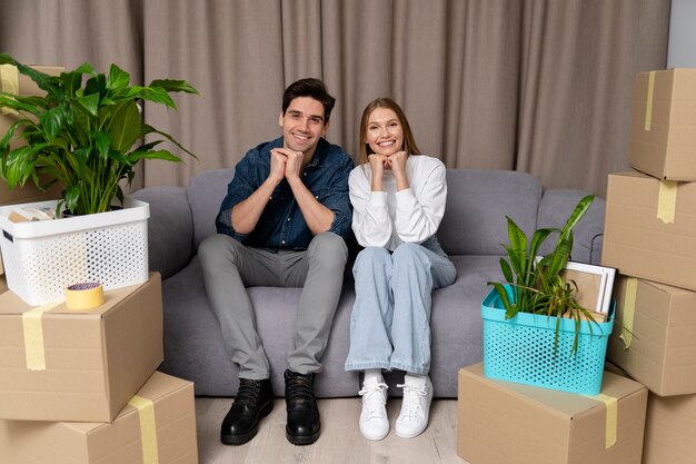 Pareja posando sentada en el sofá de su nueva casa