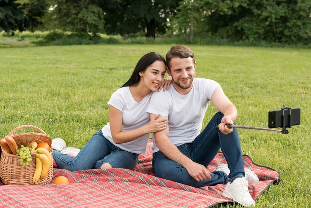 Pareja posando sobre manta de picnic