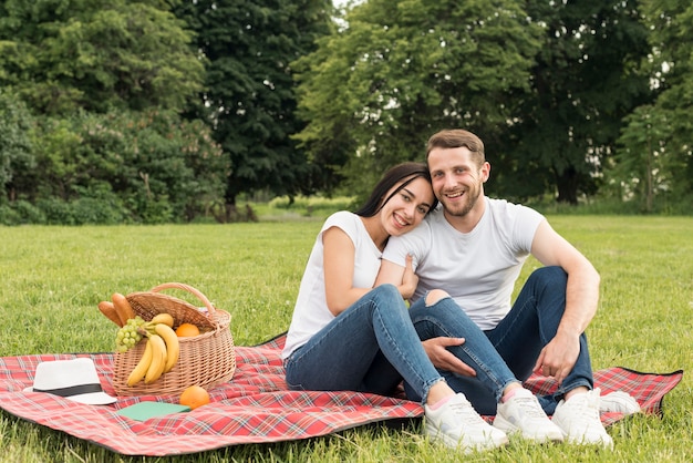 Foto gratuita pareja posando sobre manta de picnic