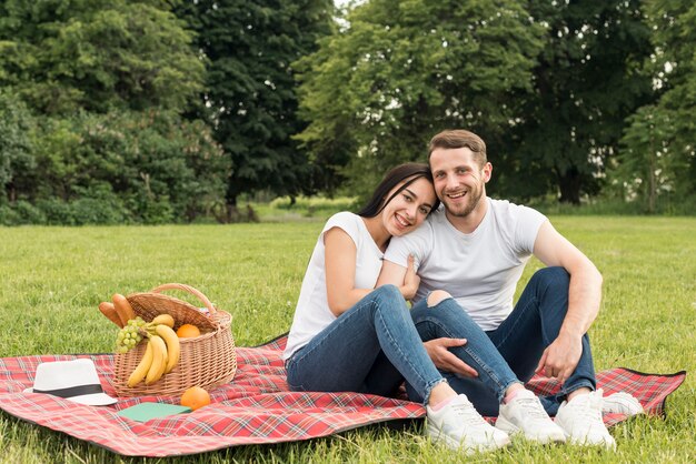 Pareja posando sobre manta de picnic