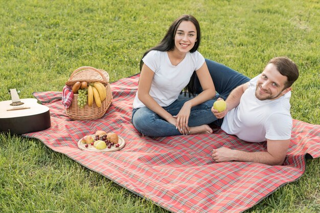 Pareja posando sobre manta de picnic