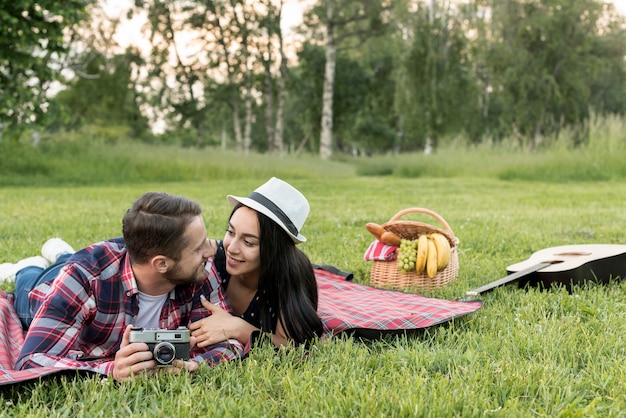 Foto gratuita pareja posando sobre manta de picnic