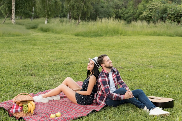 Foto gratuita pareja posando sobre manta de picnic