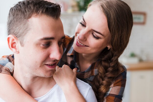 Pareja positiva abrazando en casa