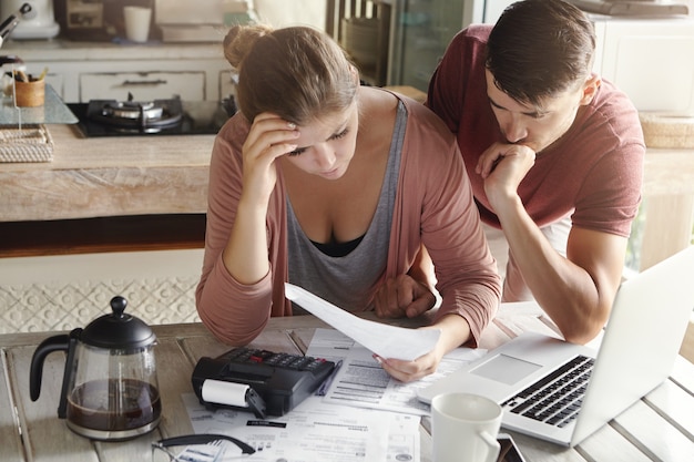 Foto gratuita pareja preocupada revisando sus finanzas familiares y calculando gastos