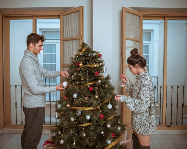 Pareja preparando el arbol para navidad