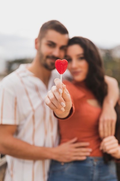 Pareja de primer plano con piruleta de corazón