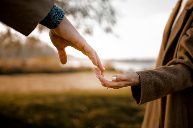 Pareja de primer plano tomados de la mano al aire libre