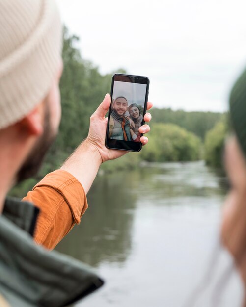 Foto gratuita pareja de primer plano tomando selfie cerca del agua