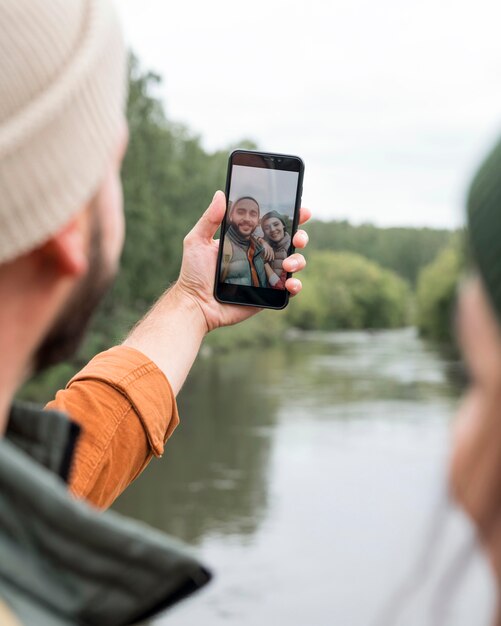 Pareja de primer plano tomando selfie cerca del agua