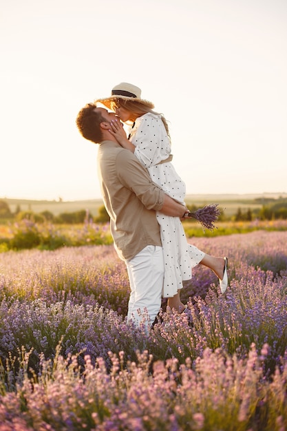 Pareja de Provenza relajante en campo de lavanda. Dama con un vestido blanco.